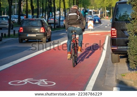 Similar – Foto Bild Radweg mit roter Fahrbahnmarkierung bei winterlichen Straßenverhältnissen.