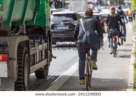 Similar – Image, Stock Photo Man riding bike next to buildings