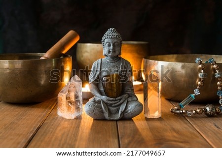Still life with singing bowls, minerals, candles and a Buddha figure on wooden boards and a dark background. Small altar illuminated with small candles for meditation and music therapy. Foto stock © 