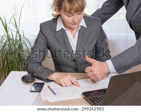 manager discussing with colleague drawings and documents