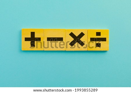 Black color of mathematical operations or Plus, minus, multiply, divide symbols on wooden cube over blue sky background use for mathematic,education,background,school concept.
