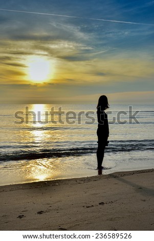 Silhouette of Sunset and women walk on the beach