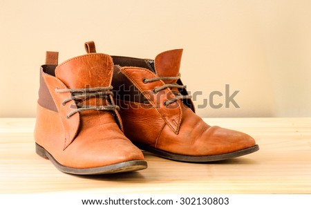 Still life with Brown leather shoes with wooden shoe stretchers on wooden table