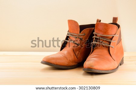 Still life with Brown leather shoes with wooden shoe stretchers on wooden table