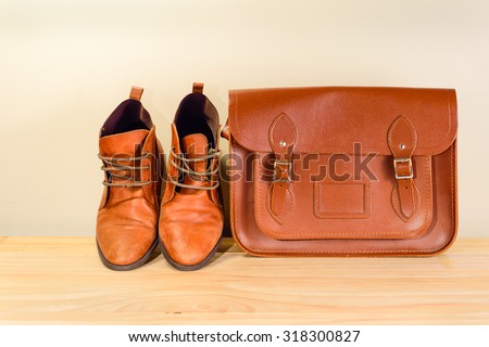 Still life with Brown leather shoes with leather bag on wooden table