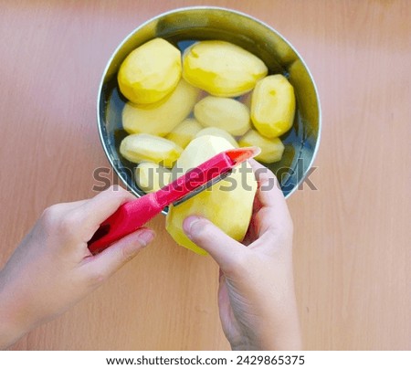 Similar – Image, Stock Photo Unrecognizable chef peeling potato in kitchen