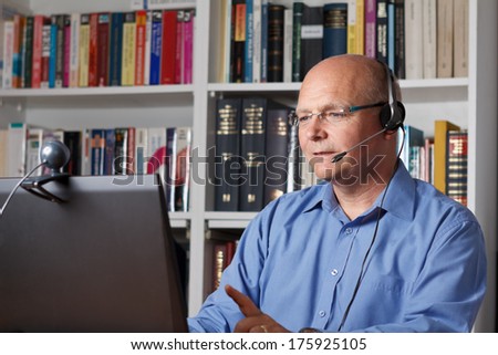 Man telephoning with computer, headset and webcam, copy space
