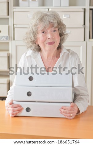 Proud retired woman holding the files folders of her property , copy space