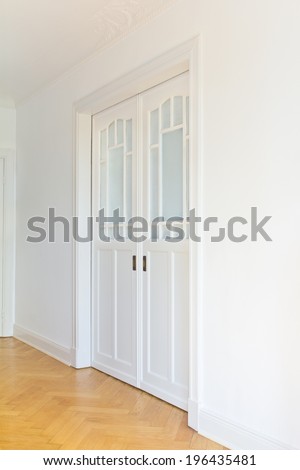 White sliding doors art nouveau style in a room with oak parquet flooring, side view, copy space