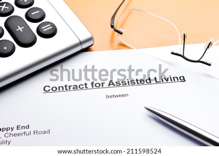Contract for Assisted Living with calculator, glasses and ballpoint pen