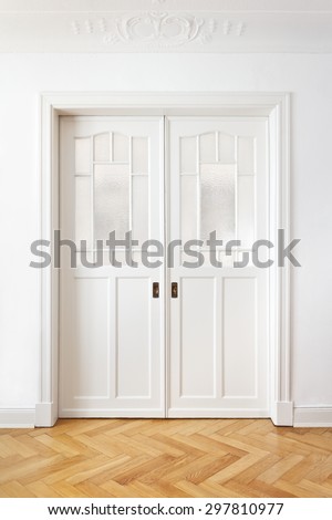 White old double sliding door with textured glass in an historic building with stucco, copy space