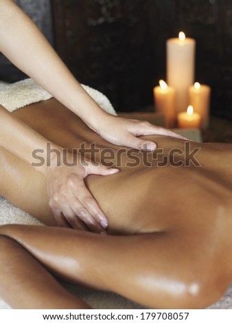 Beautiful black woman at spa being massaged