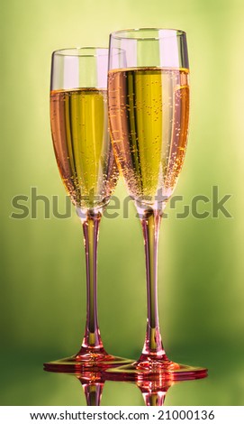 Champagne flute glasses with pink crystal base over a green background