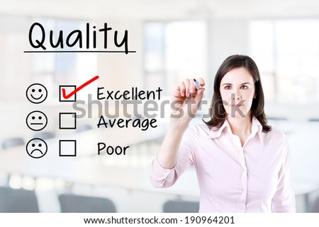 Hand putting check mark with red marker on excellent quality evaluation form. Office background.