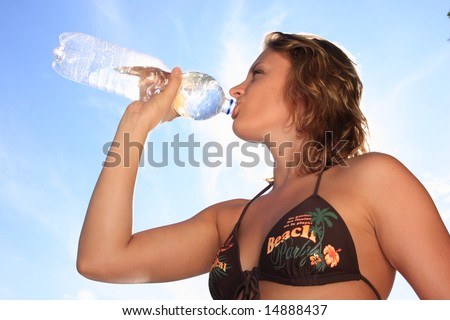 Woman drinking water at a hot summer day