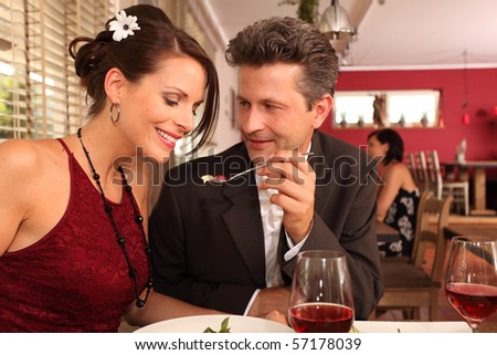 man feeding woman - love couple in a restaurant
