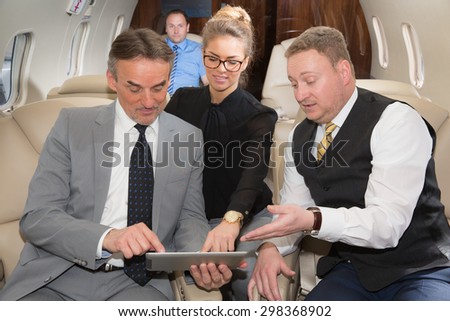 business team traveling in corporate jet and discussing a presentation