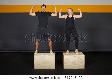 Man and woman on a fitness box - strong gesture