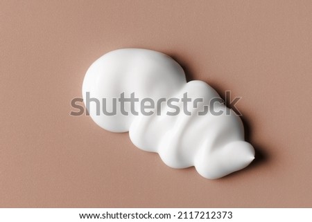 White cream texture. Cosmetic creamy product on brown background. Sunscreen, face creme, body lotion, hair conditioner swirl swatch closeup Сток-фото © 