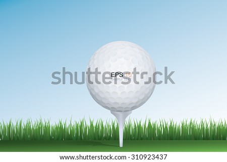 Golf ball in green grass of golf course with blue sky.