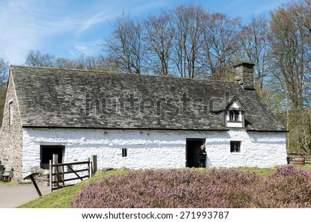 CARDIFF/UK - APRIL 19 : Cilewent Farmhouse at St Fagans National History Museum in Cardiff on April 19, 2015. Unidentified woman.