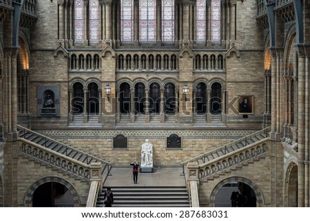 LONDON - JUNE 10 : Woman taking a photograph in the Natural History Museum in London on June 10, 2015. Unidentified people
