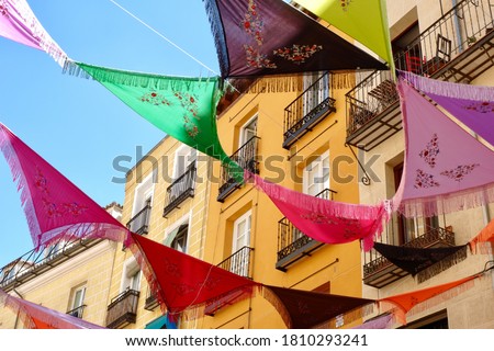 Multicolored Spanish shawls are strung between the balconies outside on the street. The decorated ambient creates a festive mood. La Latina district, Madrid, Spain Imagine de stoc © 
