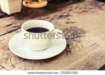 Cup of coffee on wooden table, vintage style