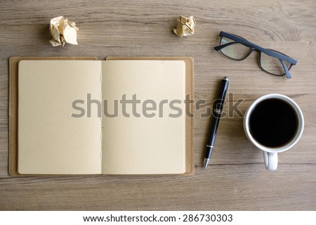 Cup of coffee with notebook on desk, workplace