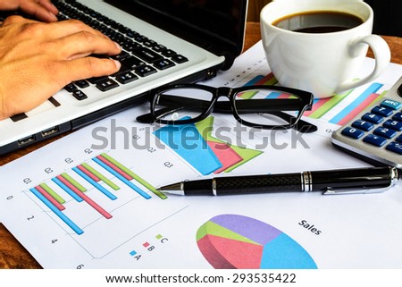 Laptop on Desk office and Graph analysis spreadsheet, Business finance
