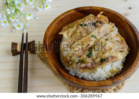 Salt and black pepper grilled pork with Japanese Rice in wooden bowl on wooden table