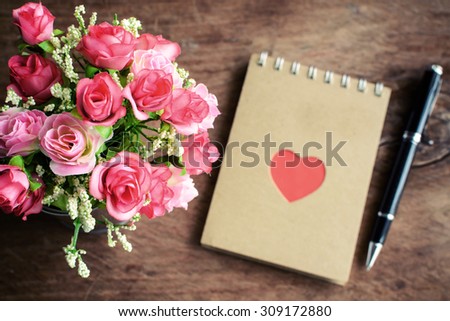 Flower with blank notepad and pen on old wooden background, Valentine\'s day and love concept