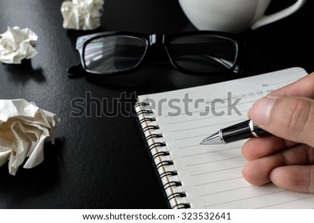 Crumpled paper balls with eye glasses and hand writing