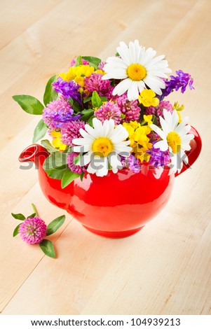 red teapot with bouquet of healing herbs and flowers, herbal medicine