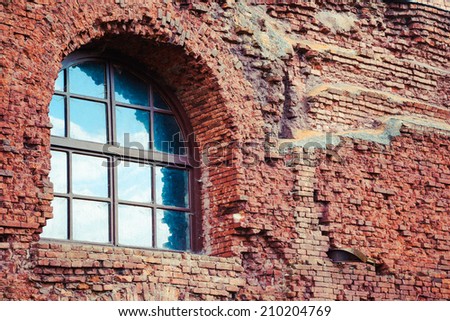arched window in a aged red brick wall