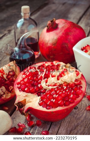 Pomegranate and bottles of essence or tincture on wooden table