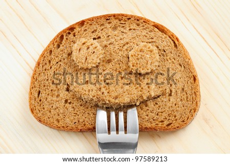 Bread slice as smiling face with with a fork in your mouth