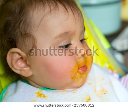 small child whose face is marred in baby food