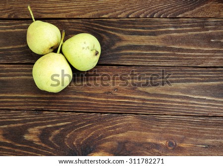 Three ripe pears on rustic table
