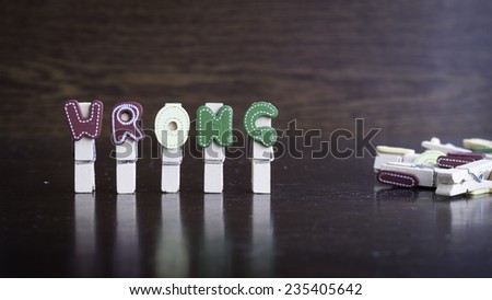 Common business terms - Slightly defocused and close-up of WRONG word on clothes peg stick with lots of clothes peg at background