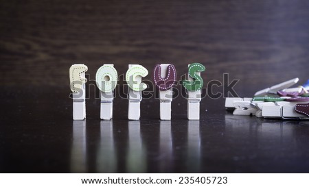 Common business terms - Slightly defocused and close-up of FOCUS word on clothes peg stick with lots of clothes peg at background