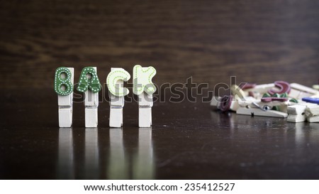 Common business terms - Slightly defocused and close-up of BACK word on clothes peg stick with lots of clothes peg at background