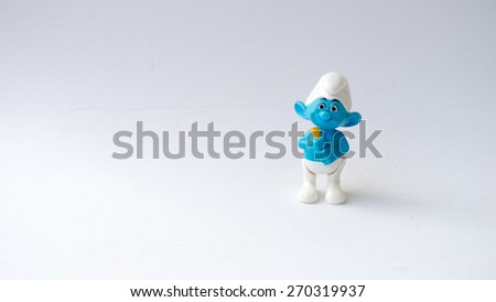 Kuala Lumpur, Malaysia - April 18, 2015: Cute Smurf toy figure on plain background. The Smurfs is a Belgian comic and tv franchise centered on a fictional colony of small blue creatures in the forest
