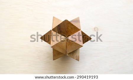 Wooden pointy cube puzzle on wooden surface. Concept of complex and smart logical thinking. Slightly defocused and close up shot. Copy space.