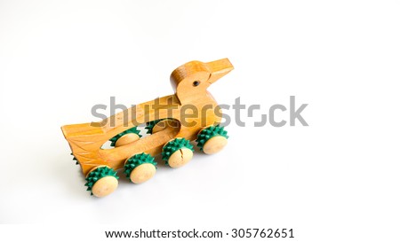 Wooden duck shape massage roller hand held massager tool. Isolated on white background. Slightly de-focused and close-up shot. Copy space.