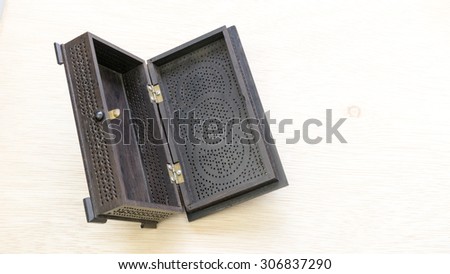 Black color vintage or traditional wooden jewellery or treasure box on wooden surface. Concept of heritage treasure. Slightly de-focused and close-up shot. Copy space.
