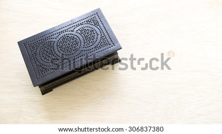 Black color vintage or traditional wooden jewellery or treasure box on wooden surface. Concept of heritage treasure. Slightly de-focused and close-up shot. Copy space.