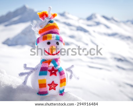 Happy snowman in mountains standing in winter landscape