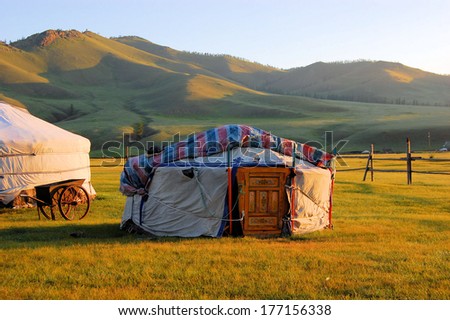 Traditional ger tent home of Mongolian nomads on the grass plains of the steppe with colorful rolling hills