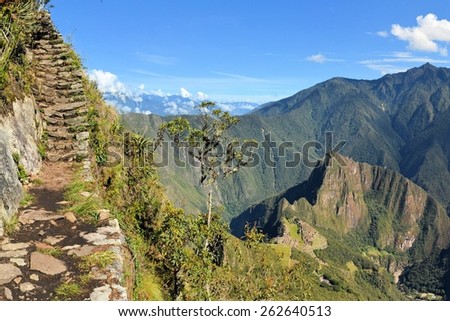 Stairs of an Inca trail up Macchu Picchu mountain with the lost city way below. Machhu Picchu is the famous lost city of the Incas near the river Urubamba located in the region of the sacred valley of